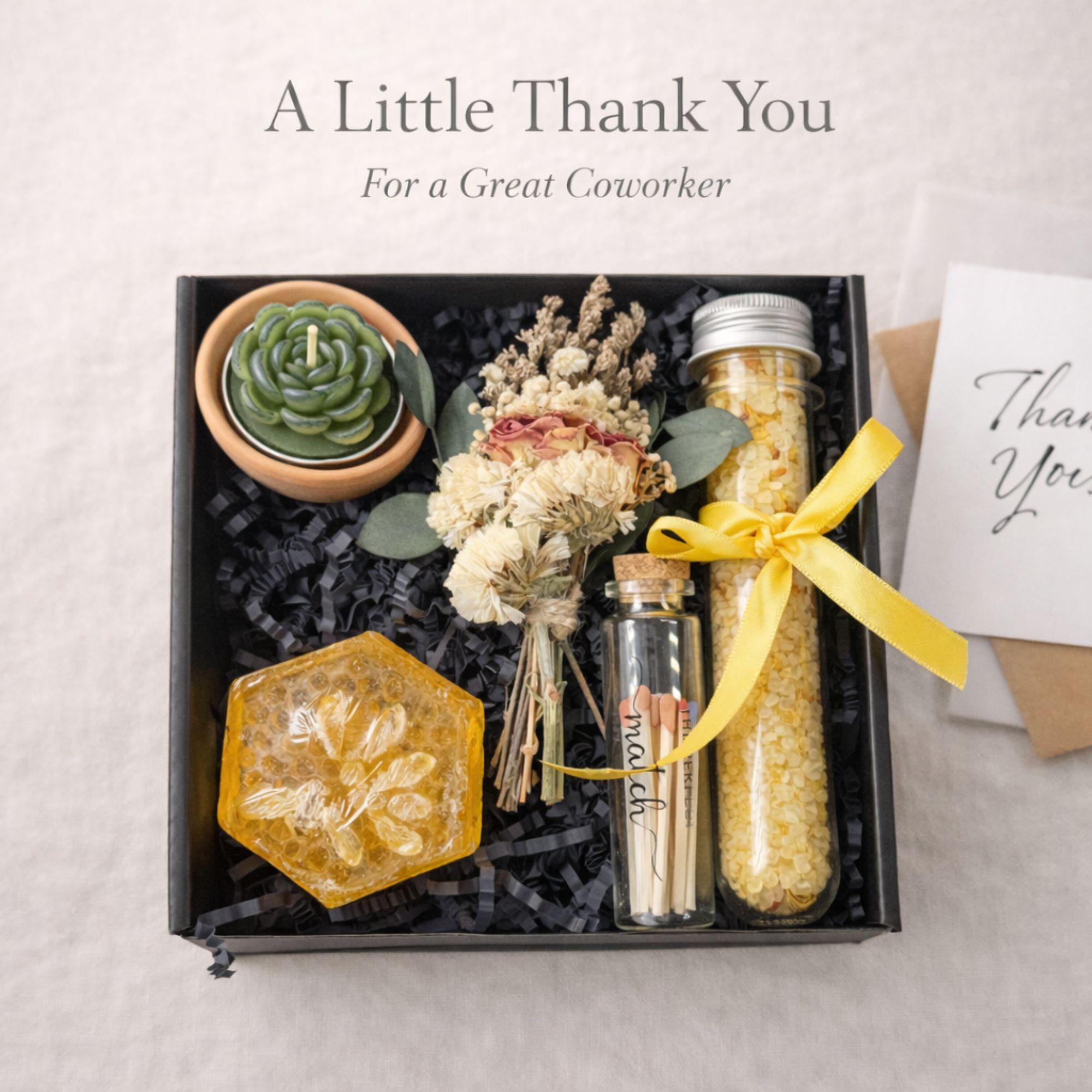 Small coworker appreciation gift box featuring succulent candle, handmade soap, bath salts, matches and dried flowers in black box with yellow ribbon, thoughtful thank you gift for coworker, friend or office team, compact 6x6 inch care package perfect for desk gift, employee appreciation, workplace gifting and meaningful everyday thank you presents