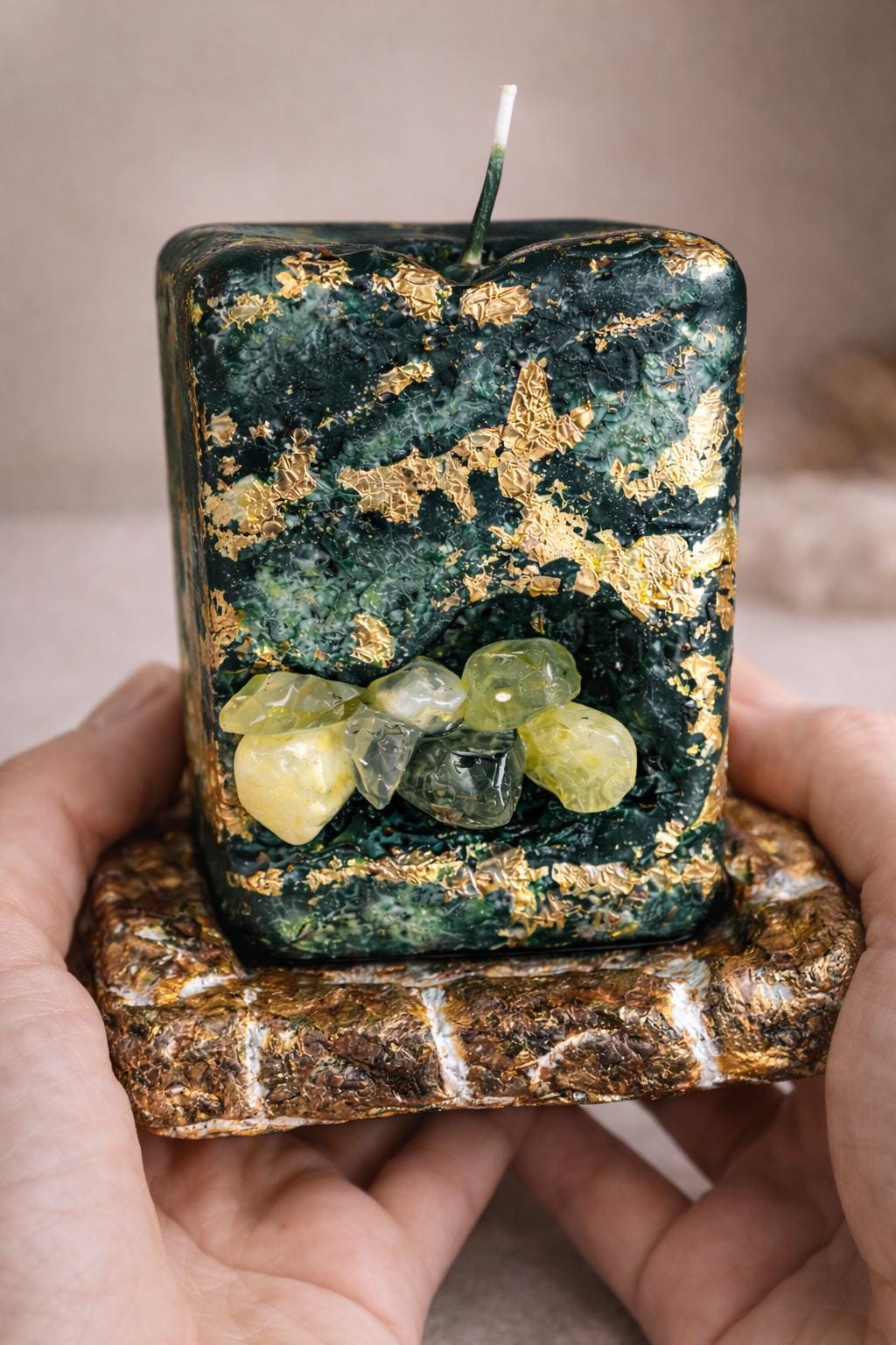 hand holding green prehnite crystal candle showing size handmade luxury candle with gold leaf