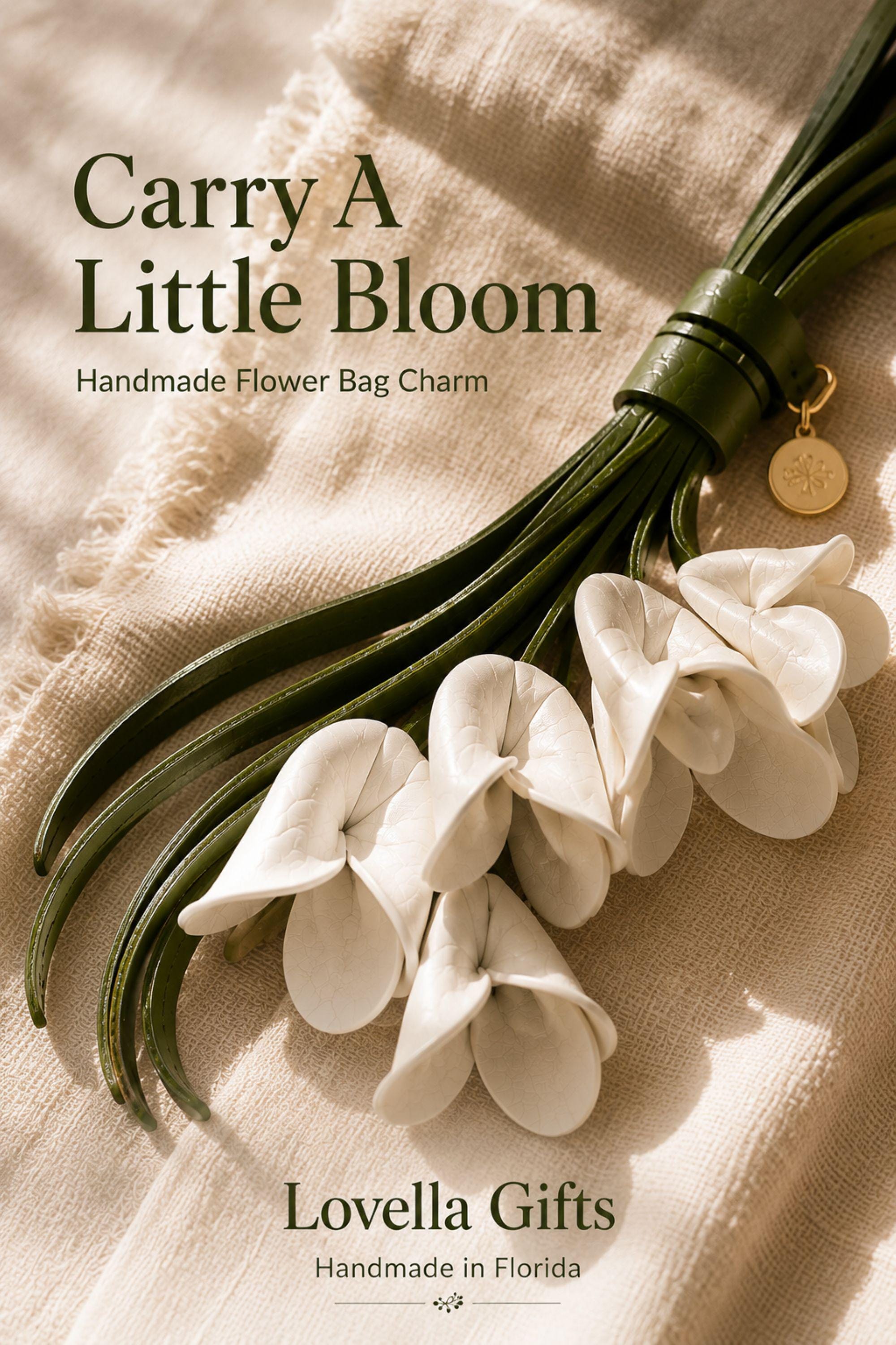 Handmade white flower bag charm featuring delicate white leather flowers attached to flowing green leather tassels with gold hardware. Floral purse charm designed for tote bags, handbags, backpacks, woven straw bags, beach bags, canvas totes, and everyday purses. Lightweight handbag accessory inspired by cottagecore, boho, feminine, and floral fashion trends. Unique gift for women, mom, sister, daughter, best friend, bridesmaid, and flower lovers.