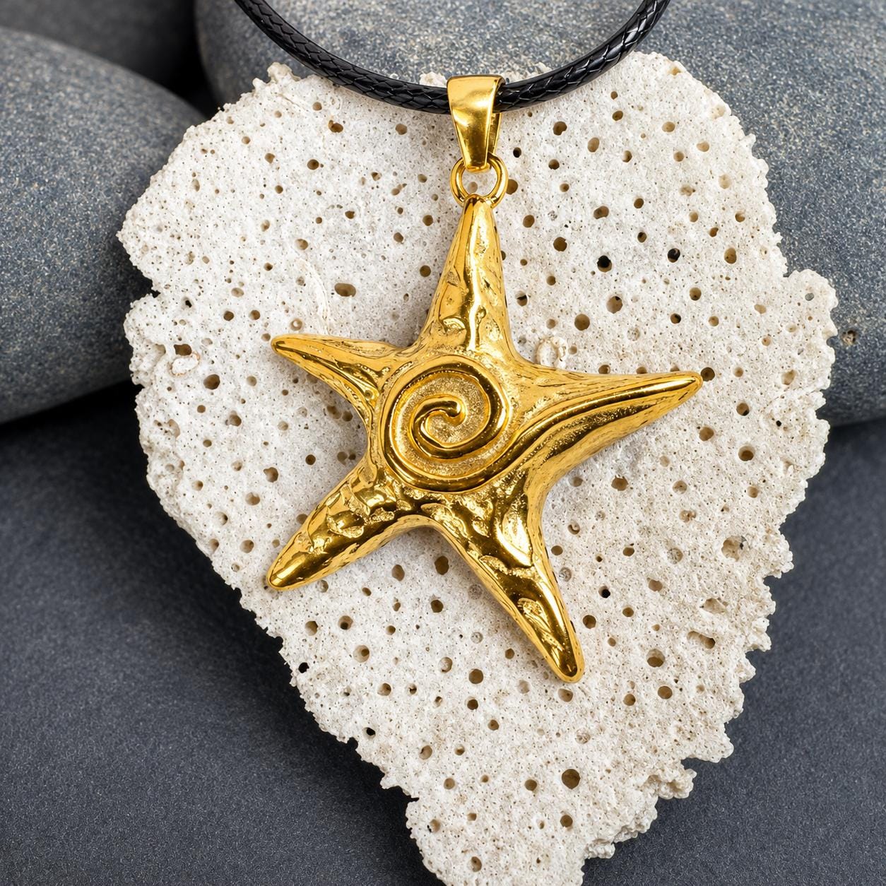 Gold star necklace featuring a textured starfish pendant with elegant spiral center detail, inspired by coastal treasures and ocean beauty.