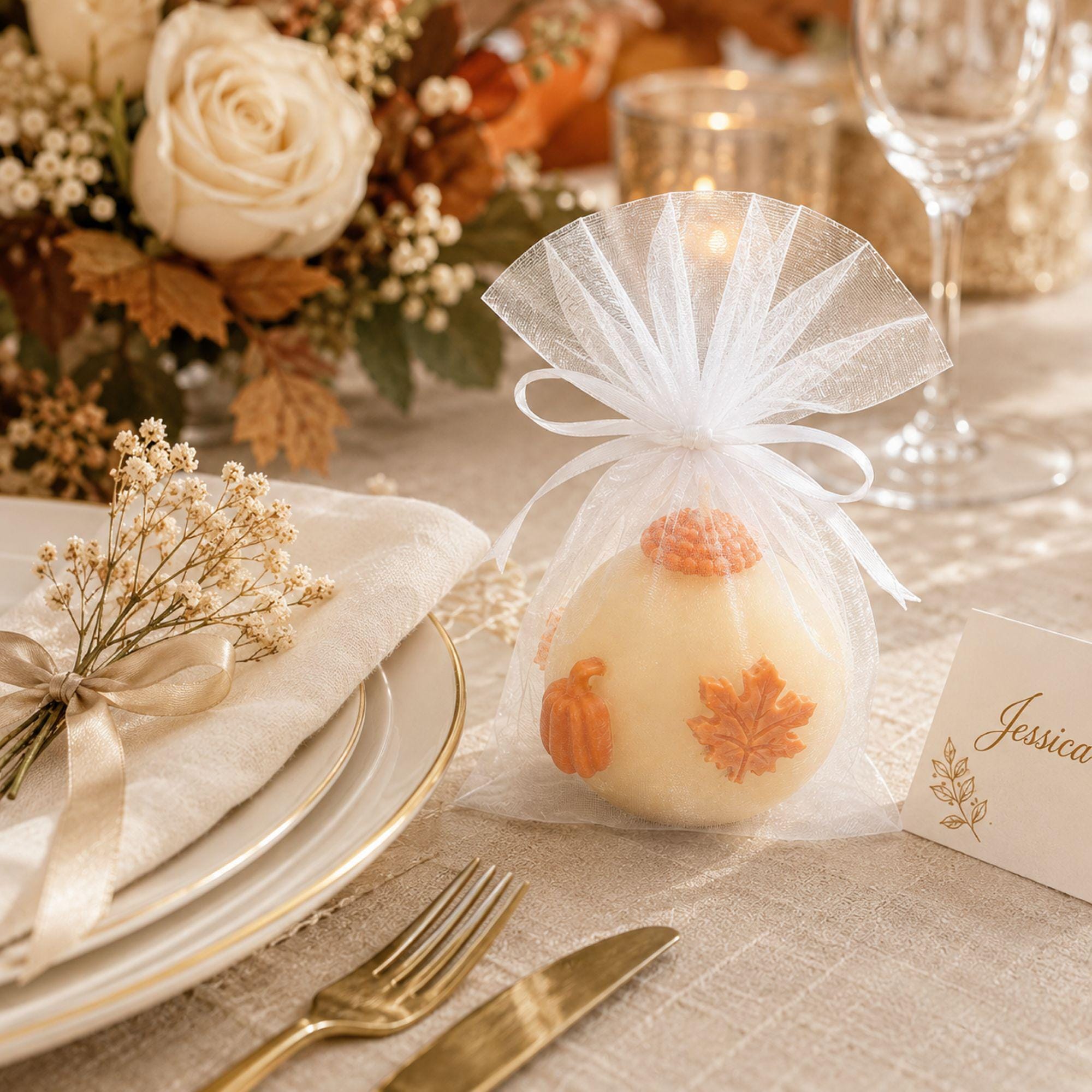 Handmade fall wedding favor featuring a 3 inch ivory sphere pumpkin candle with orange autumn maple leaf and pumpkin details, beautifully presented as a rustic wedding guest gift. Unique autumn wedding favor for October and November weddings, bridal showers, engagement parties, rehearsal dinners and fall celebrations. Individually wrapped in white organza for an elegant gift-ready presentation.
