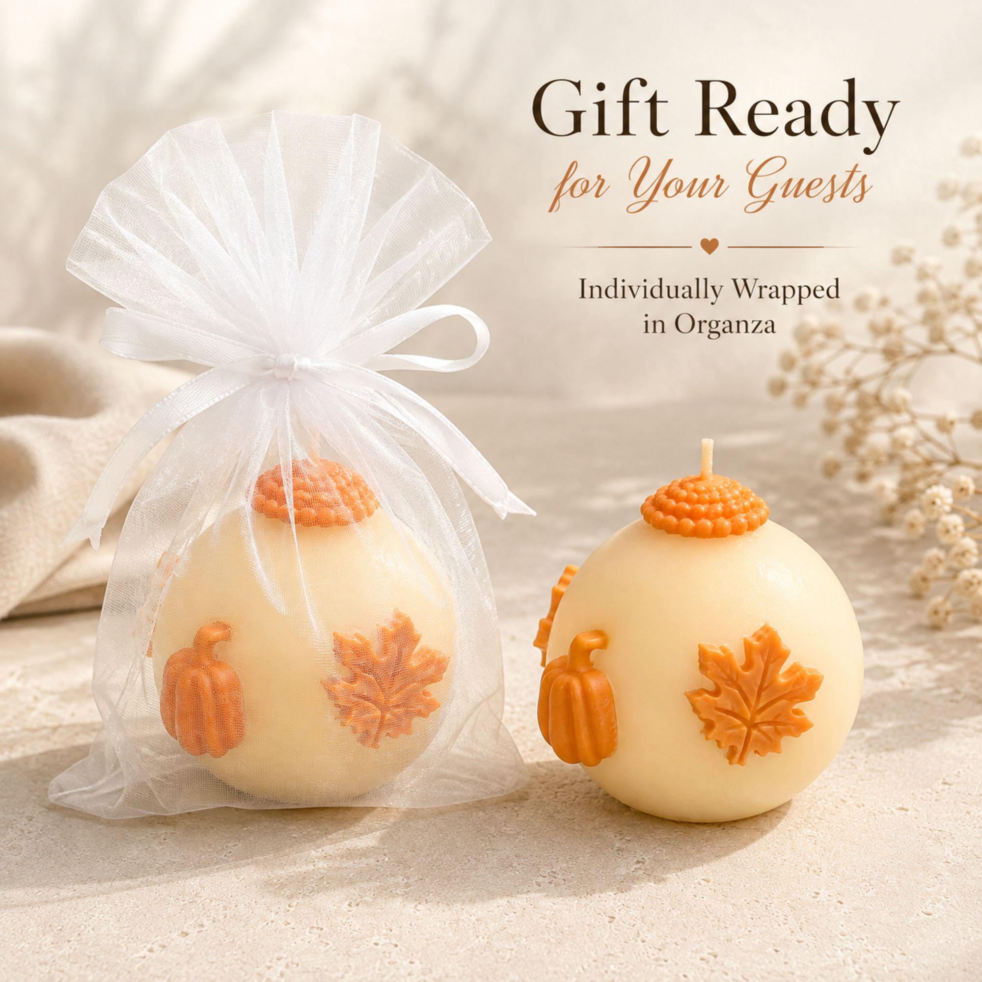 Handmade fall wedding favor featuring a 3 inch ivory sphere pumpkin candle with orange autumn maple leaf and pumpkin details, beautifully presented as a rustic wedding guest gift. Unique autumn wedding favor for October and November weddings, bridal showers, engagement parties, rehearsal dinners and fall celebrations. Individually wrapped in white organza for an elegant gift-ready presentation.