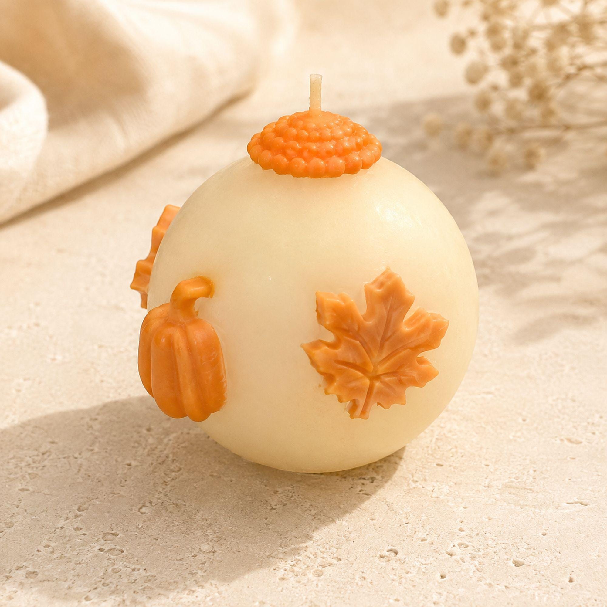 Handmade fall wedding favor featuring a 3 inch ivory sphere pumpkin candle with orange autumn maple leaf and pumpkin details, beautifully presented as a rustic wedding guest gift. Unique autumn wedding favor for October and November weddings, bridal showers, engagement parties, rehearsal dinners and fall celebrations. Individually wrapped in white organza for an elegant gift-ready presentation.